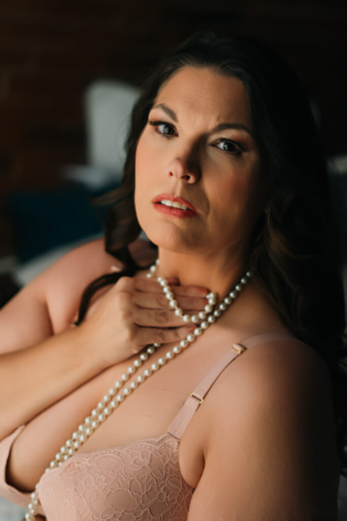 woman wearing pearls looking into camera 